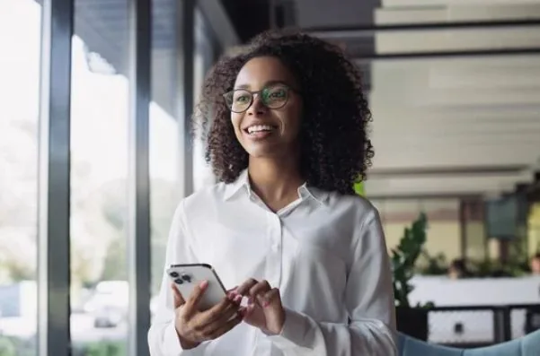 Ondernemer met smartphone in kantoor – SayYes2Lease