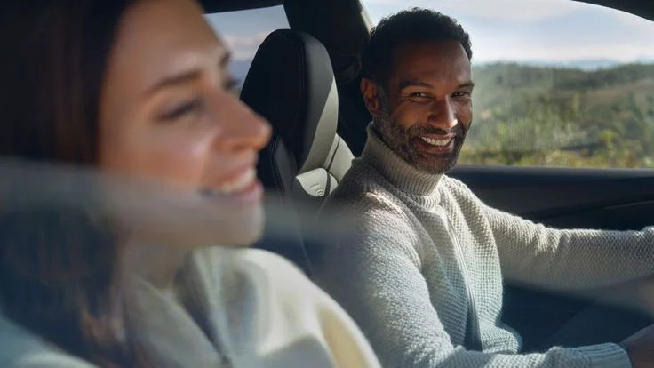 Twee mensen in een auto tijdens het rijden – SayYes2Lease